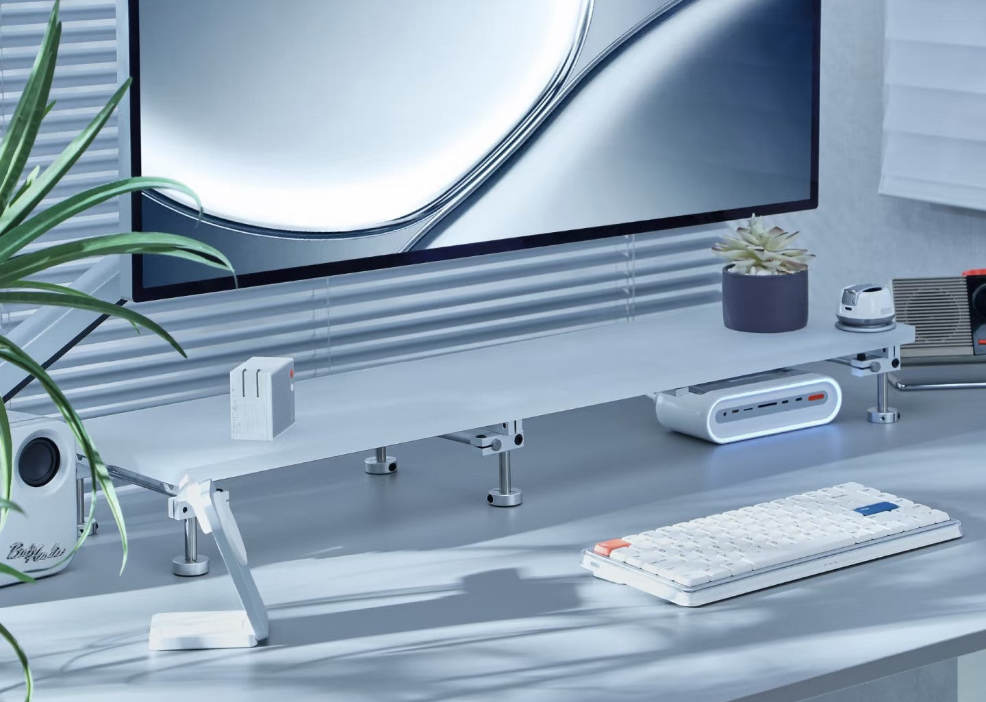chrome steel acrylic monitor riser on a minimal home office desk setup