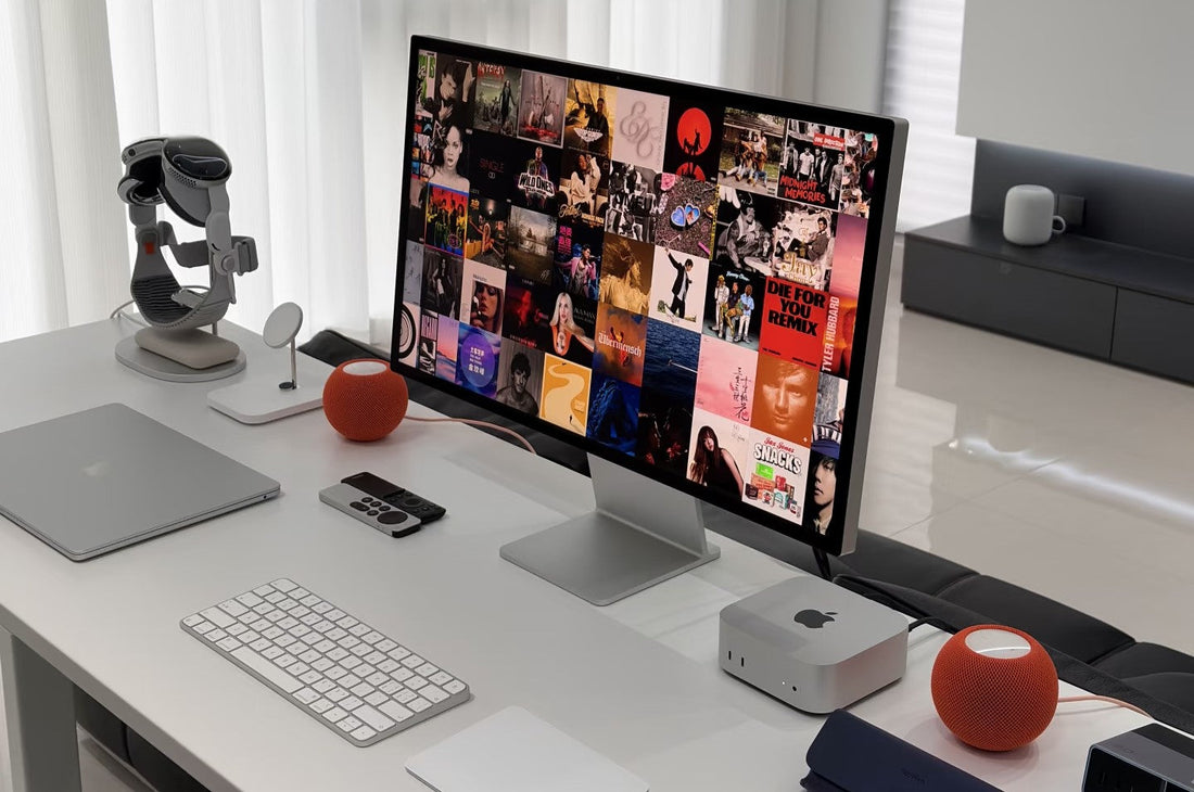 Custom clear acrylic monitor riser with chrome steel frame supporting an Apple Studio Display on a minimal desk setup