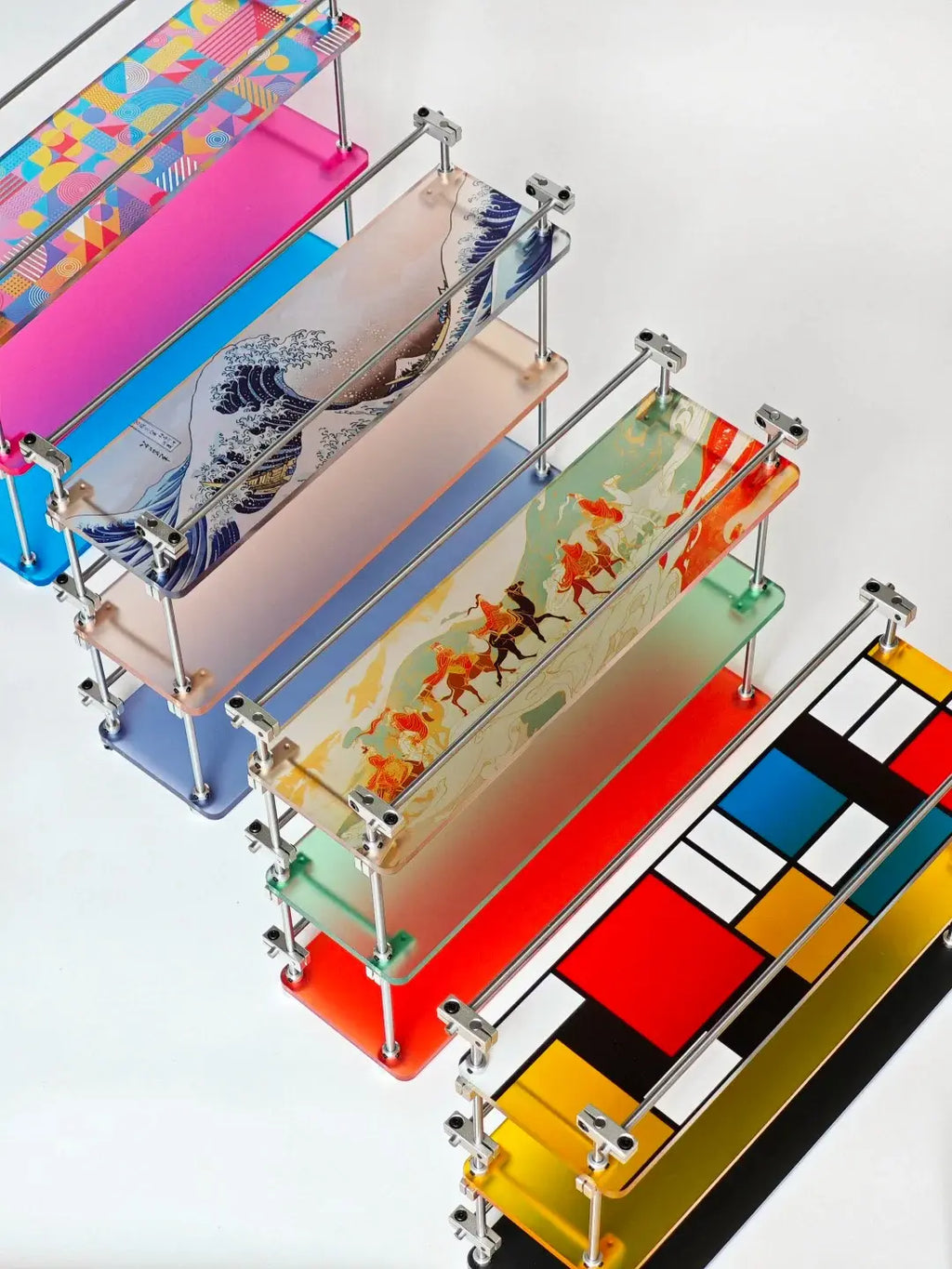 HushLume 3-Tier Display Stand with custom UV-printed acrylic panels — multiple colorways including Great Wave, goldfish, geometric, and Mondrian-style designs on chrome steel shafts