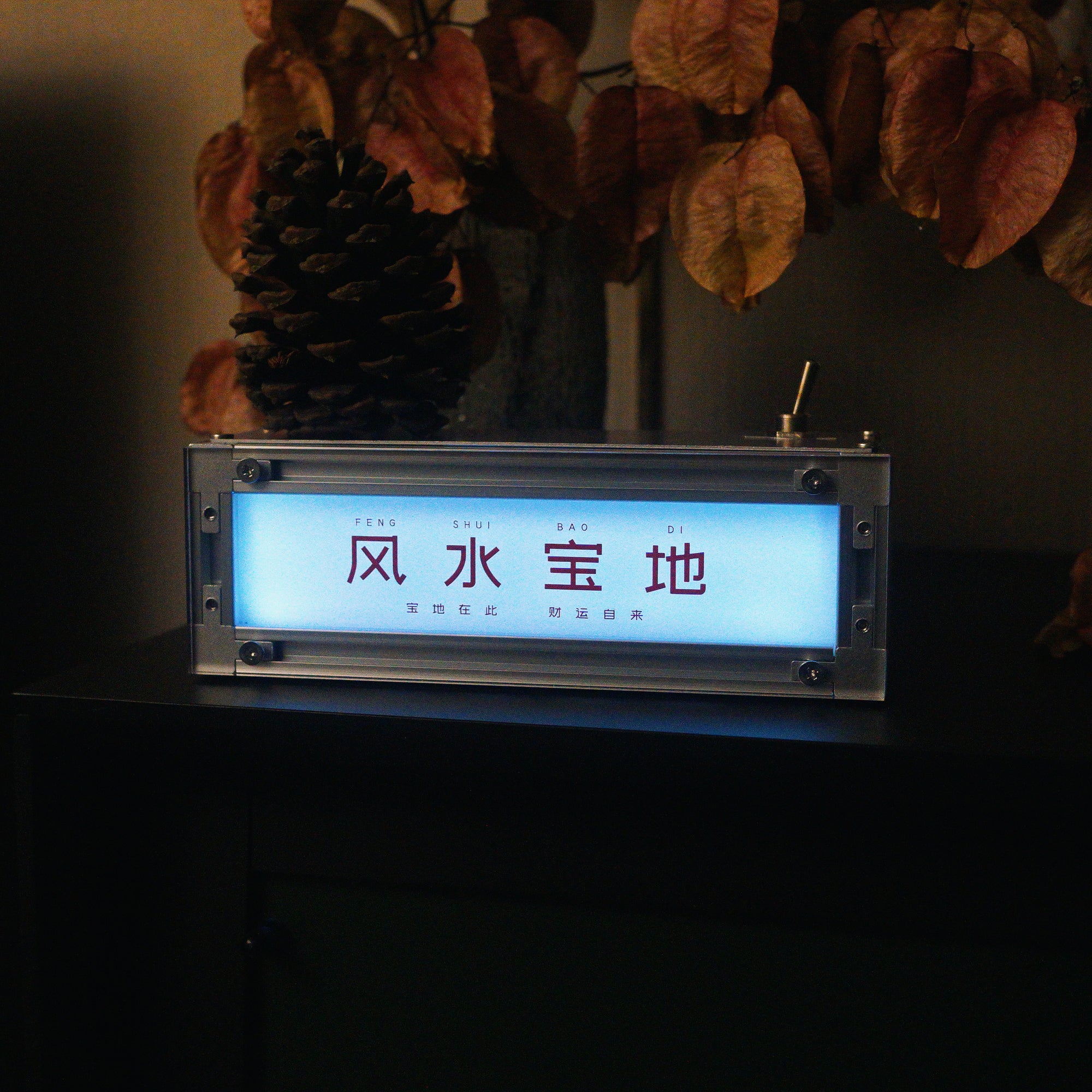 Lifestyle shot of the HushLume smart industrial light box illuminated in cool cyan blue, demonstrating the smart app RGB color-changing feature on a dark desk.