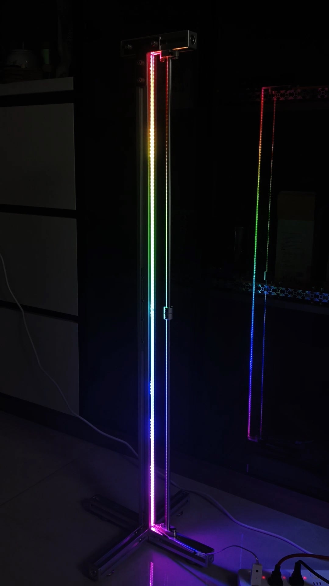 HushLume 3030 aluminum industrial RGB floor lamp illuminating with a vibrant rainbow gradient effect in a dark gaming room setup.