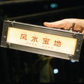 Handheld shot of HushLume smart industrial light box made with 1515 aluminum extrusions and a customizable 5mm acrylic panel, displaying glowing custom text.